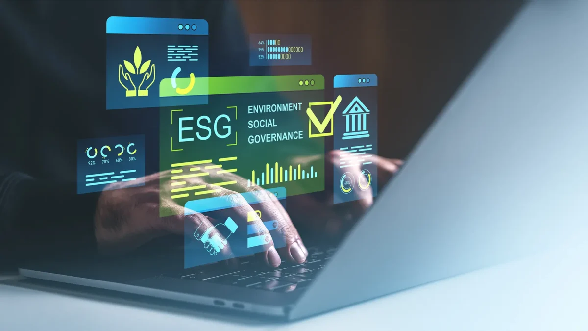 Hands typing on a laptop with holographic ESG metrics