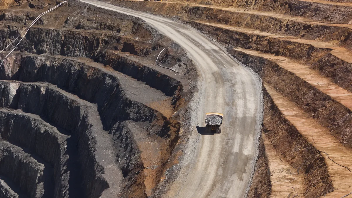 Two trucks transport gold ore from an open-cast mine