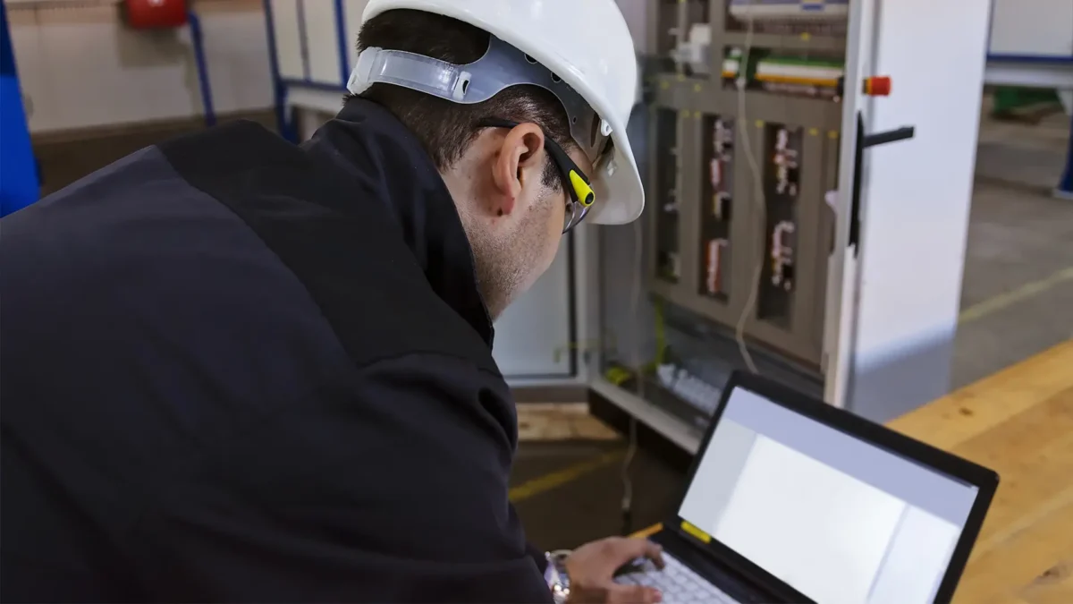 A worker checking an advanced industrial control panel